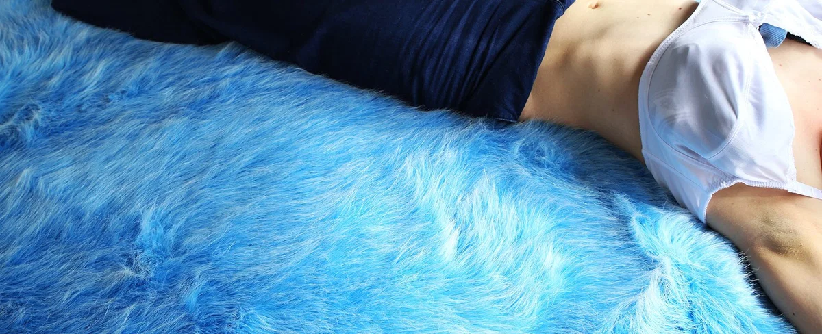 body lying on blue bed color photography by inge van heerde