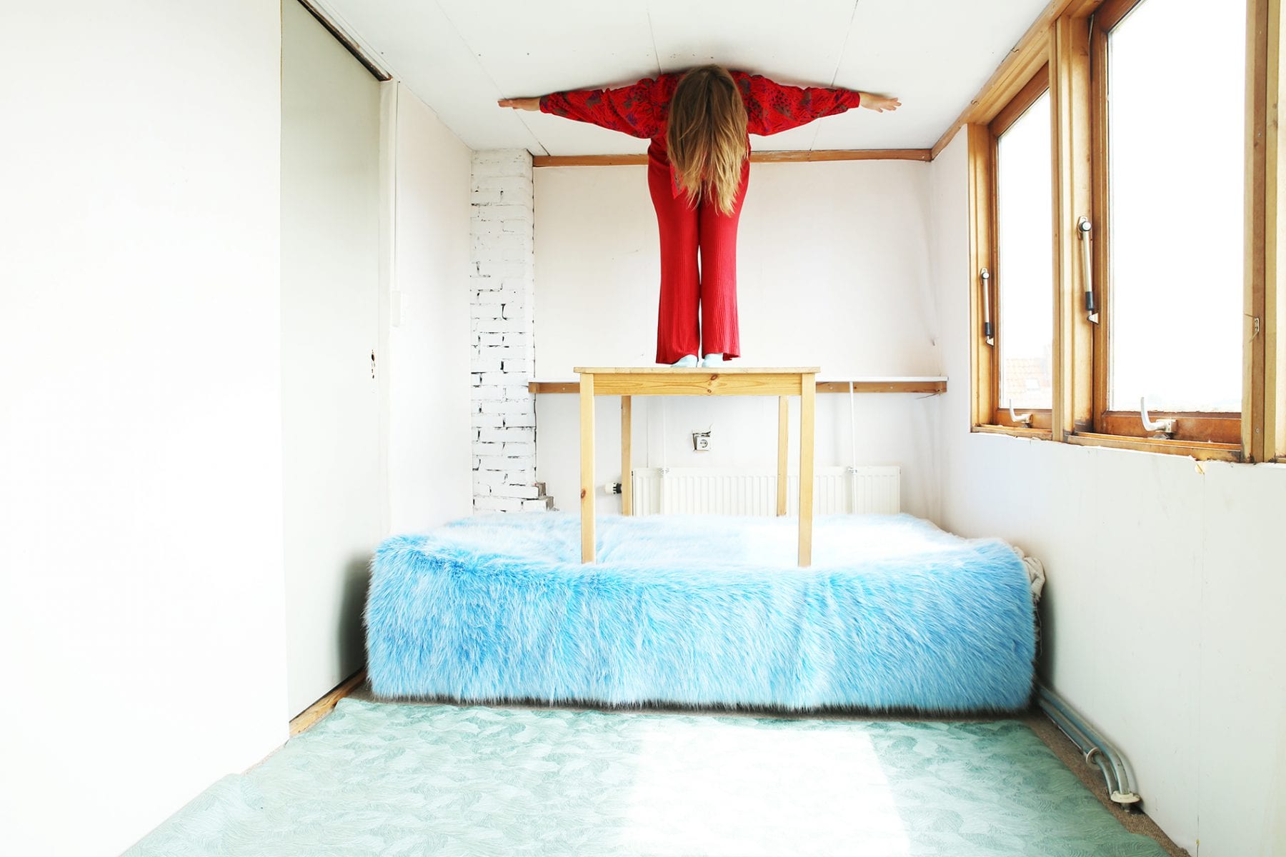 woman on blue bed color photography by inge van heerde