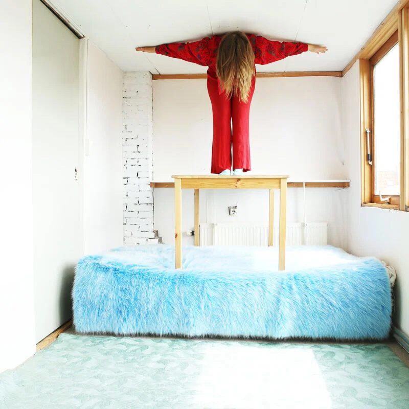 woman on blue bed color photography by inge van heerde