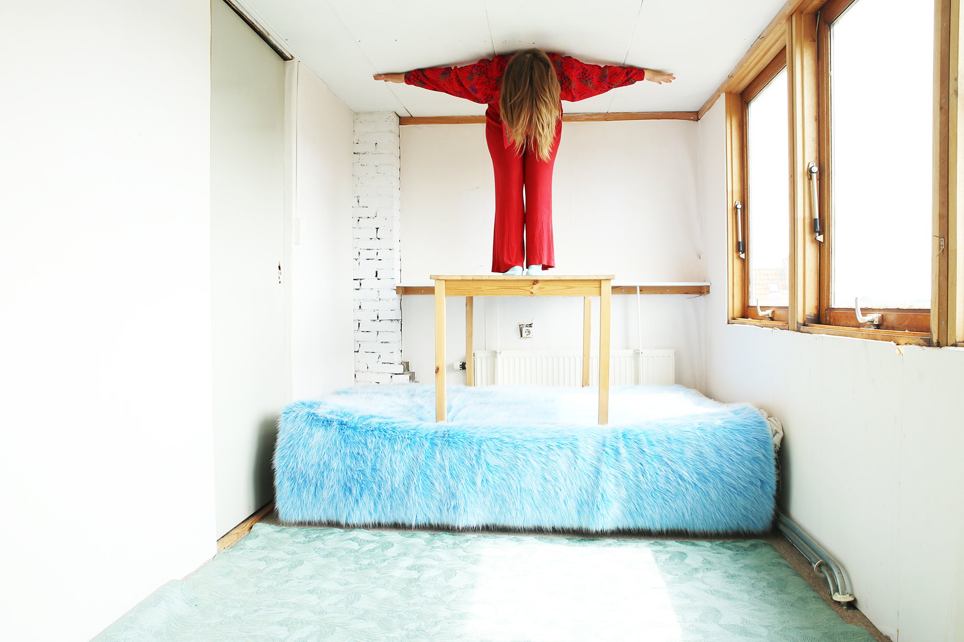 woman on blue bed color photography by inge van heerde