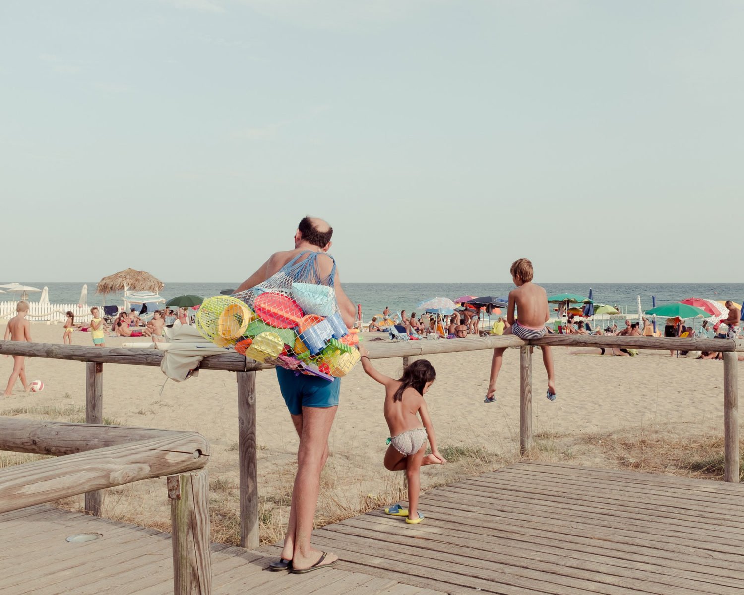 color photograph of a man with children on the beach in Italy by Alessio Pellicoro