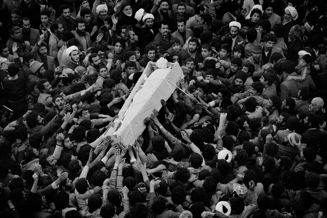 The body of Ayatollah Moffateh, shrouded in white, is taken to the cemetery by a large crowd of mourners, Iran, December 1979 © Abbas