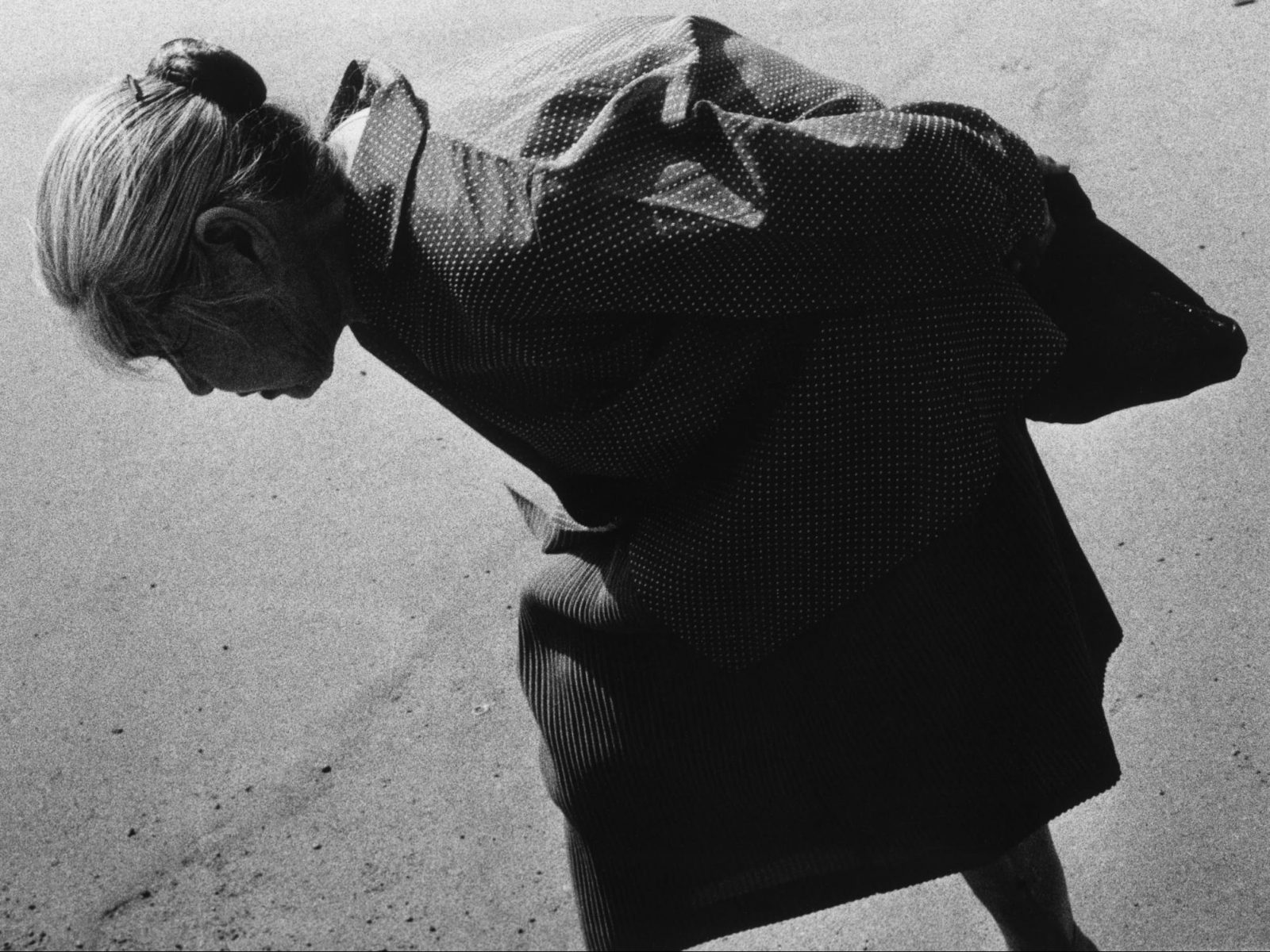 Schwarzweiss-Porträt einer älteren Frau, die in Tokio, Japan geht. Foto von Issei Suda