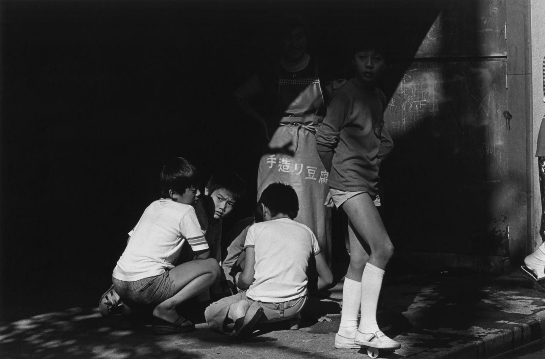 Schwarzweiss-Porträt von drei Jungen in Tokio, Japan durch Issei Suda
