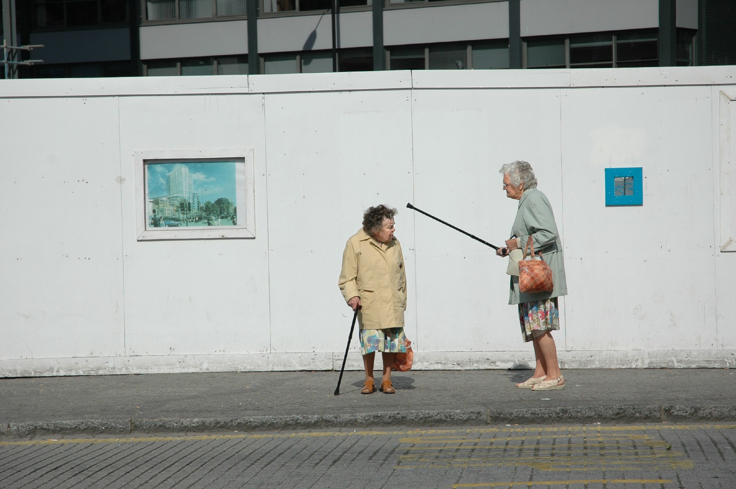 Fotografía callejera en color de mujeres ancianas argumentando por Paul Russell