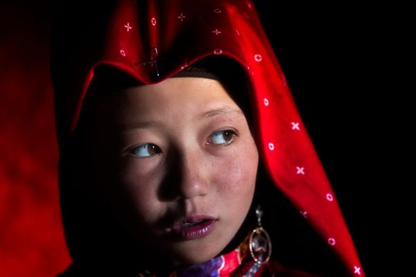 Color portrait photograph of a young kirghiz girl in red dress in Kyrgyzstan - Visual Storytelling Award