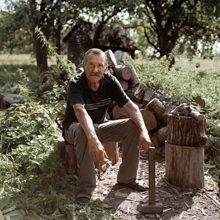Color photograph by Tadas Kazakevičius, from Soon to be Gone portrait, chopping wood, trees
