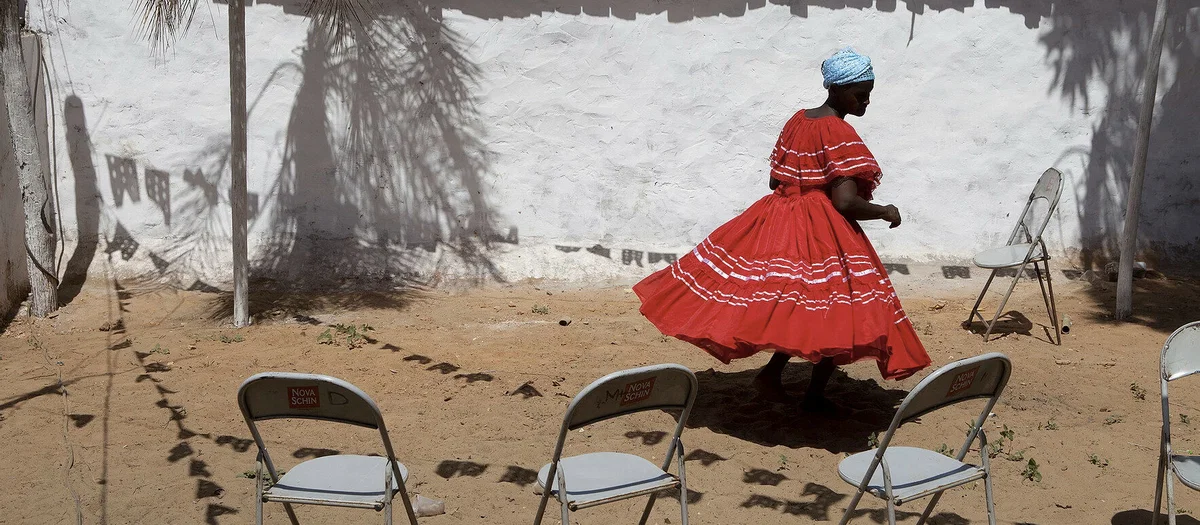 Color film photo of a woman in red dress by Brazilian photographerAlex Almeida