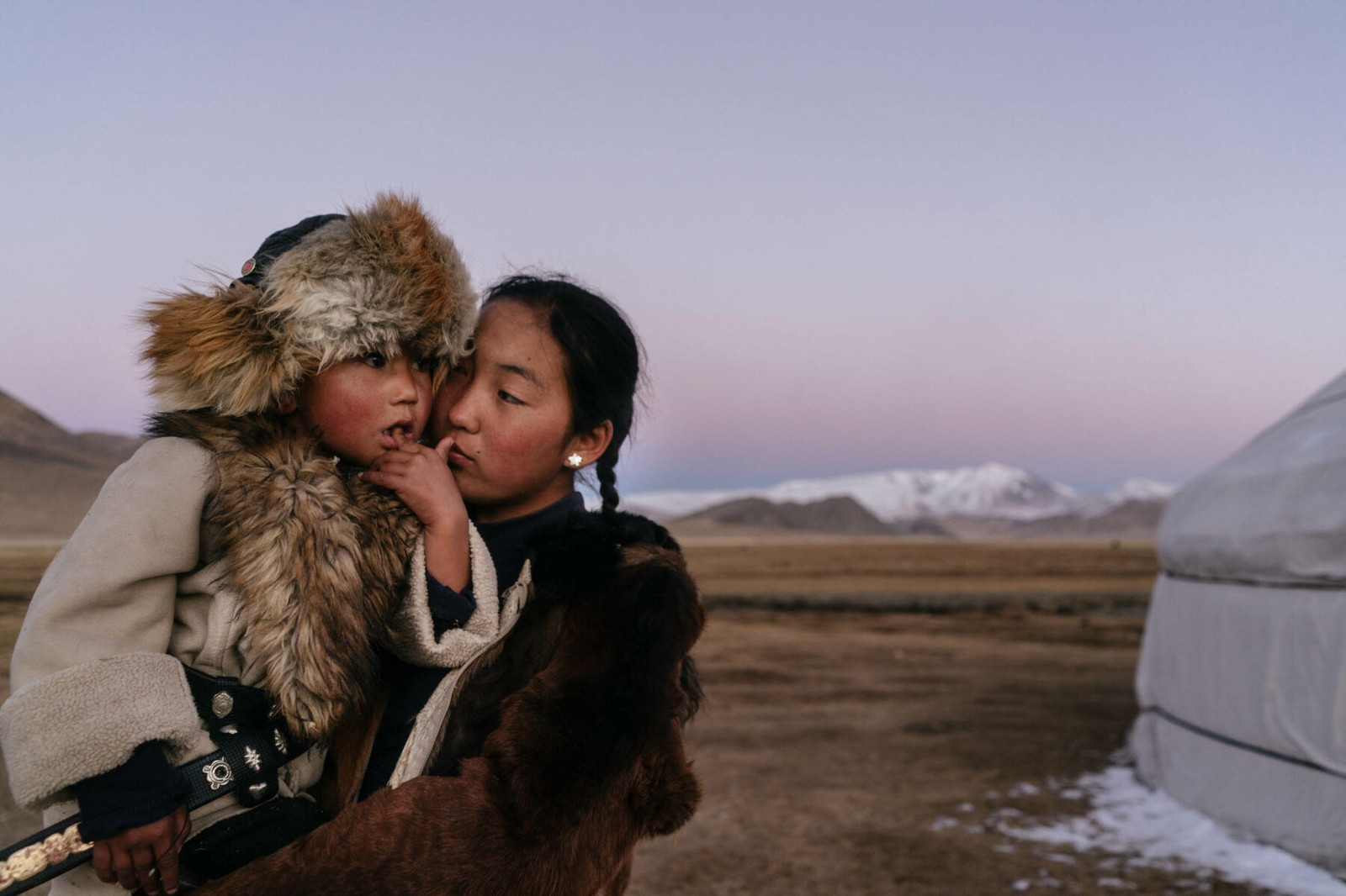 Talap Zamanbol, 14 ans, est vu avec Bazarbai Dinismal, un parent plus jeune en formation pour devenir fauconnier à Bayan Ulgii, en Mongolie. Photographie couleur par Hannah Reyes Morales de la série 'Eagle Hunters'