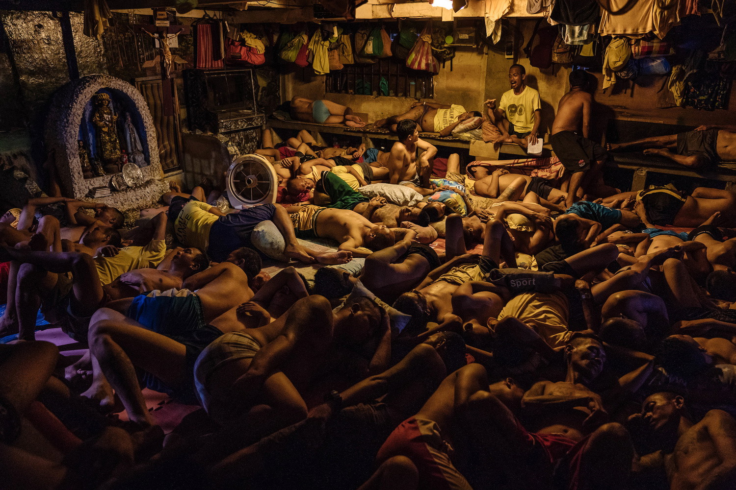 Des détenus dorment près d'une petite grotte de Marie dans la prison de la ville de Manille, aux Philippines, le 31 octobre 2018. De la série "Manila City Jail", photographie documentaire de Hannah Reyes Morales