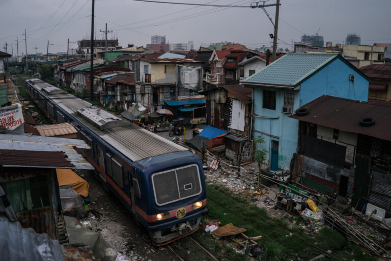 De la série "Season of Darkness" de Hannah Reyes Morales. Train traversant les bidonvilles des Philippines.