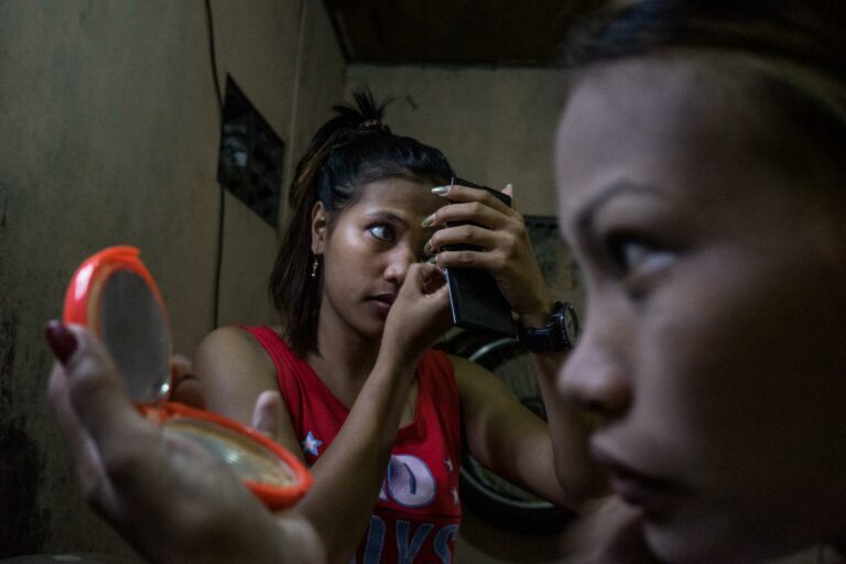 Photographie documentaire de Hannah Reyes Morales, de la série « Shelter from the Storm ». deux travailleuses du sexe se maquillent. Les Philippines