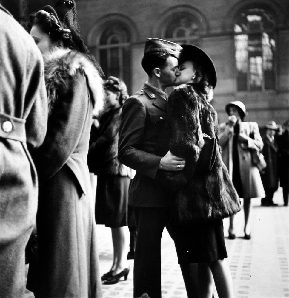 Couple in Penn Station sharing farewell kiss before he ships off to war during WWII, NY, 1943. Black and white photography by Alfred Eisenstadt