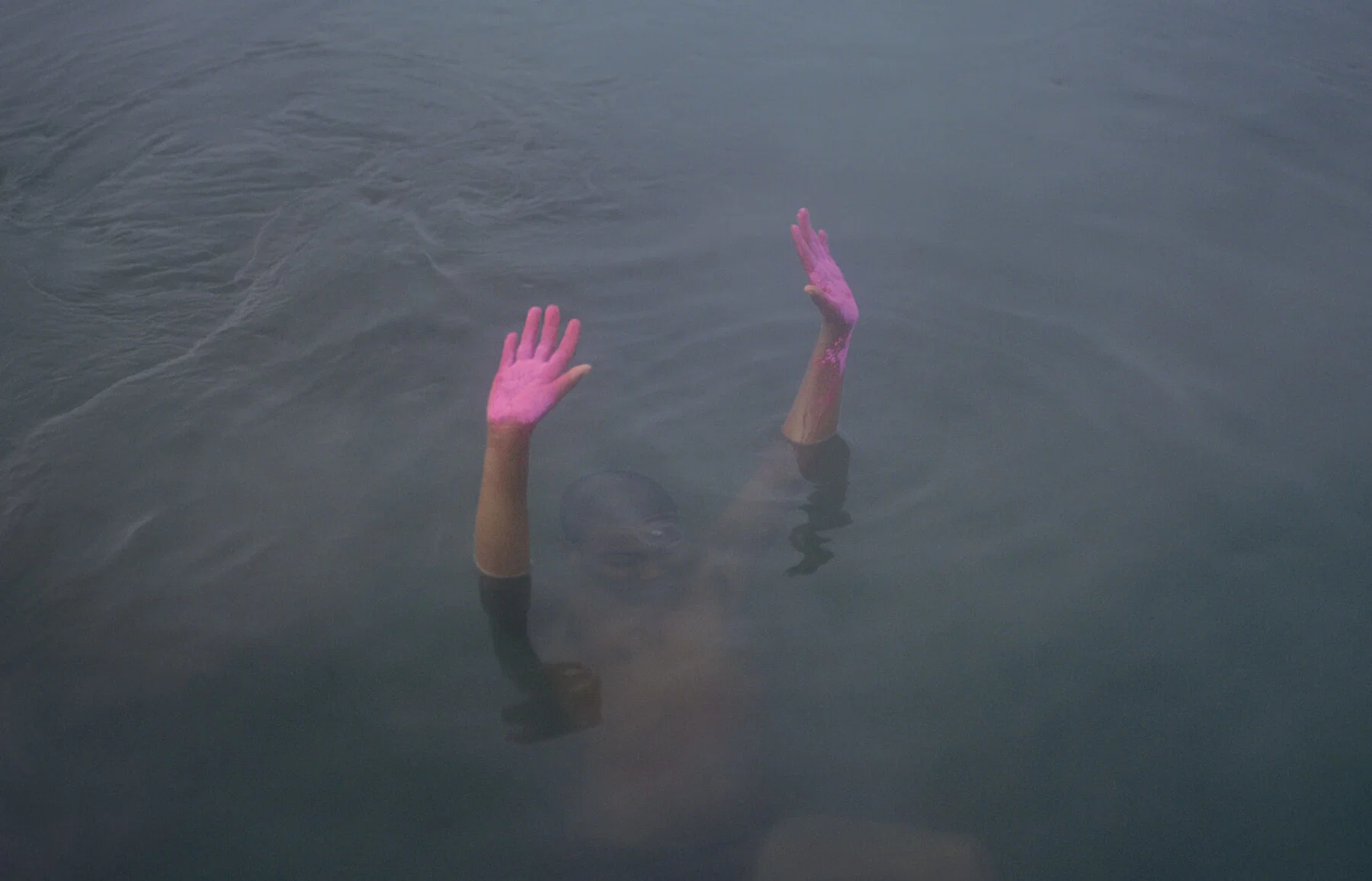 Color photo of boy with pink hands in water by Kin Coedel