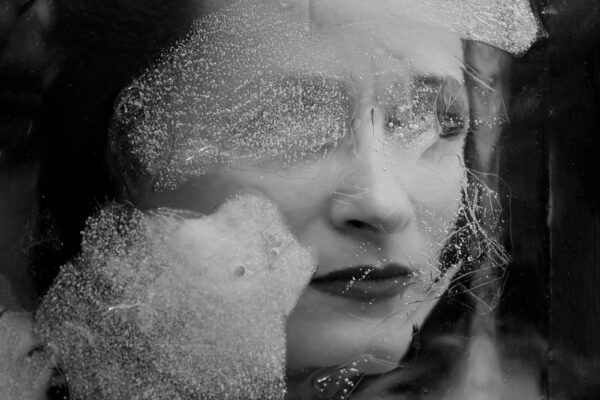 black and white abstract portrait of a woman behind ice