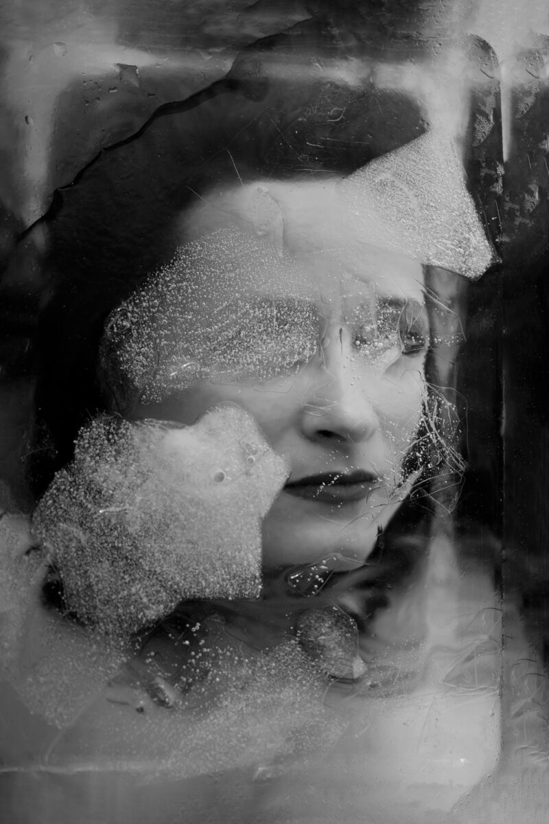 black and white abstract portrait of a woman behind ice