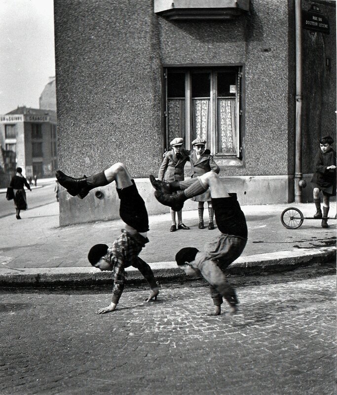Foto in bianco e nero di due ragazzi che giocano, di Robert Doisneau. Parigi, Francia, 1934