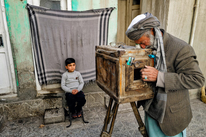 color portrait photo of man and boy with old wooden camera by Laurin Strele