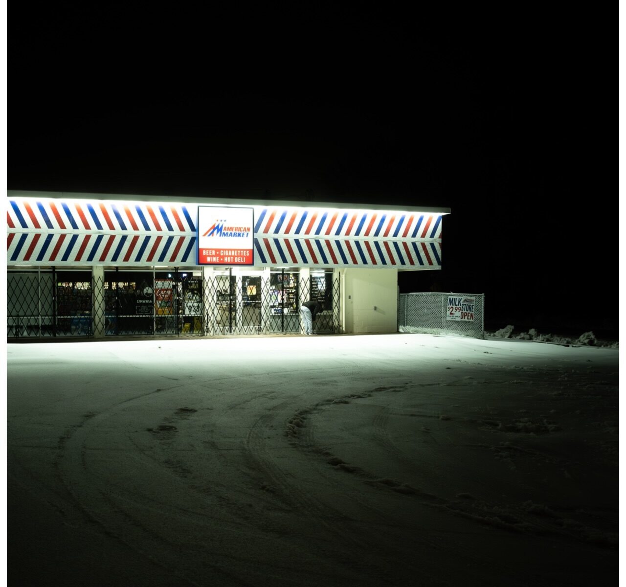 Color landscape photography by Bill Holderfield. Store illuminated at night, and snow-covered road