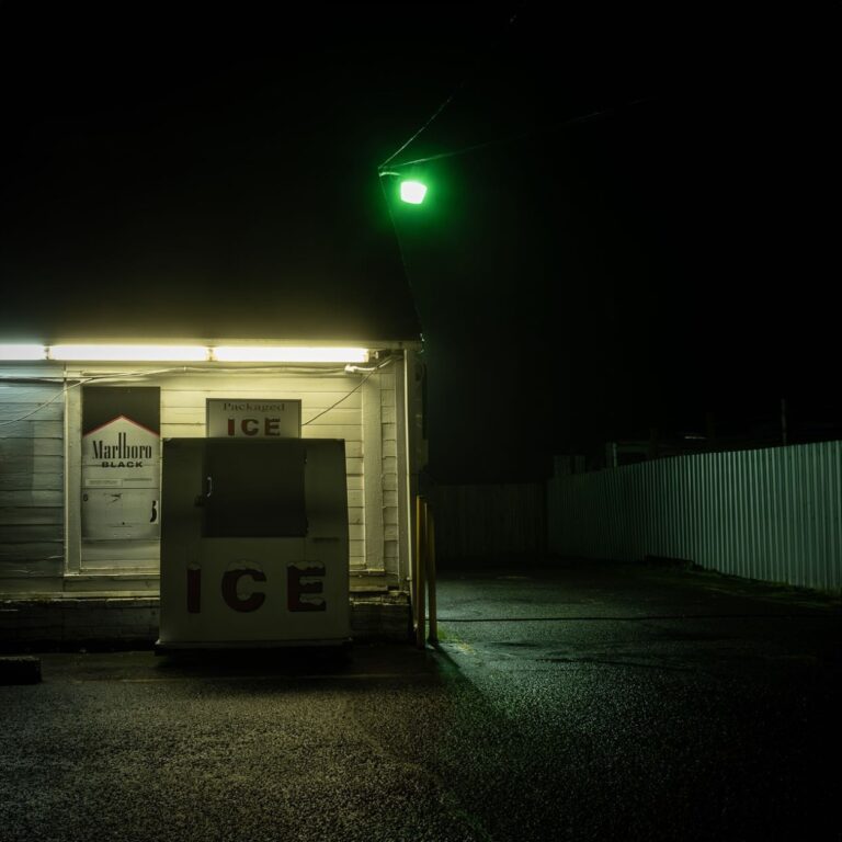 Color landscape photography by Bill Holderfield. Storefront illuminated by green light. USA