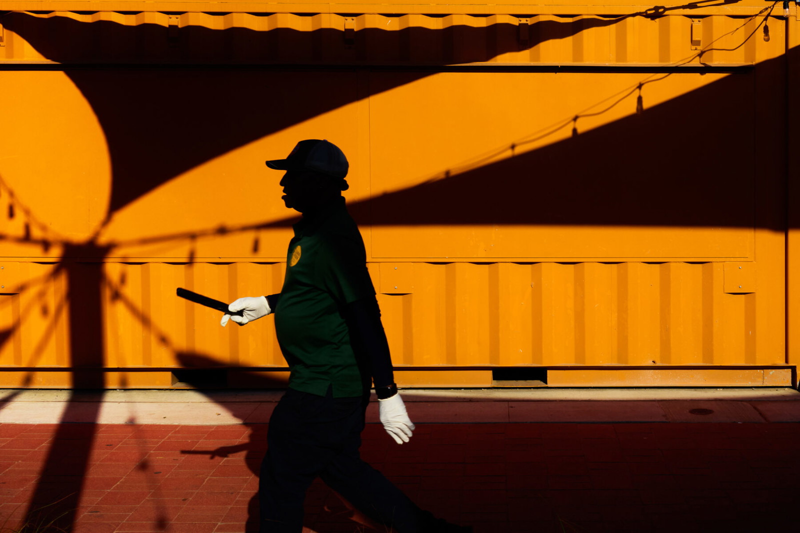 color street photography of man shadow with white gloves in Coney Island, NYC, USA, 2024 by Jean-Marc Bara