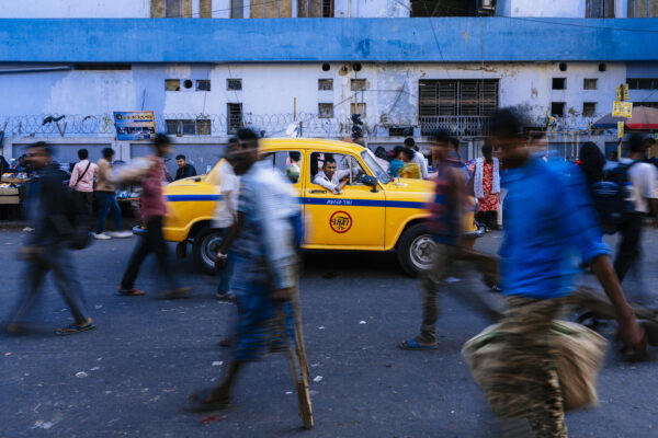 color street photography of taxi and people in Kolkota, India byMarius Burgelman