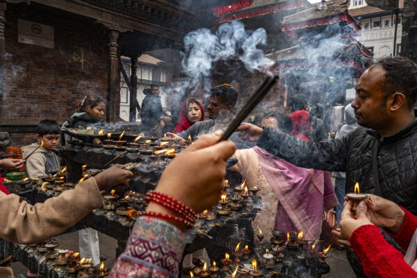 color street photography of locals making offering in temple in Kathmandu, Nepal by Roger Chen