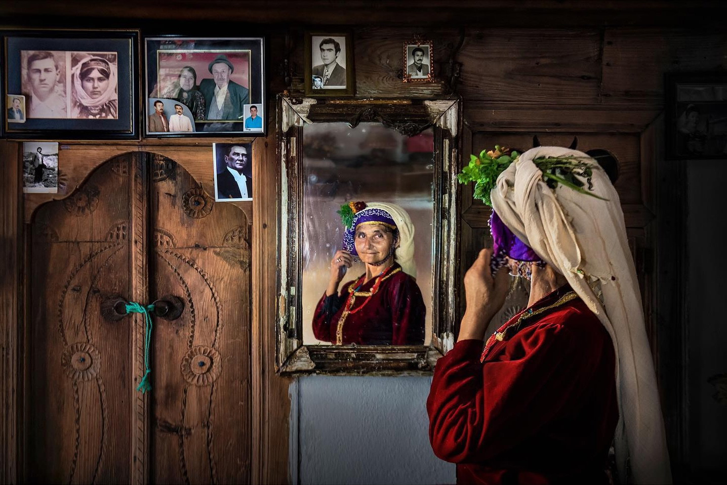 Portrait of a woman in Turkey wearing traditional clothes looking at her reflection in the mirror by F. Dilek Yurdakul