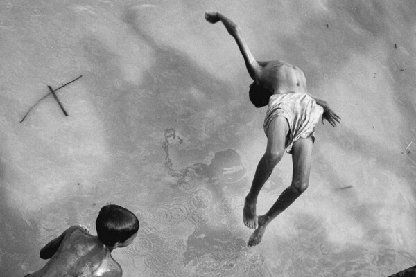 Black and white photo of children playing in water in Yangon, Myanmar, by Gil Kreslavsky