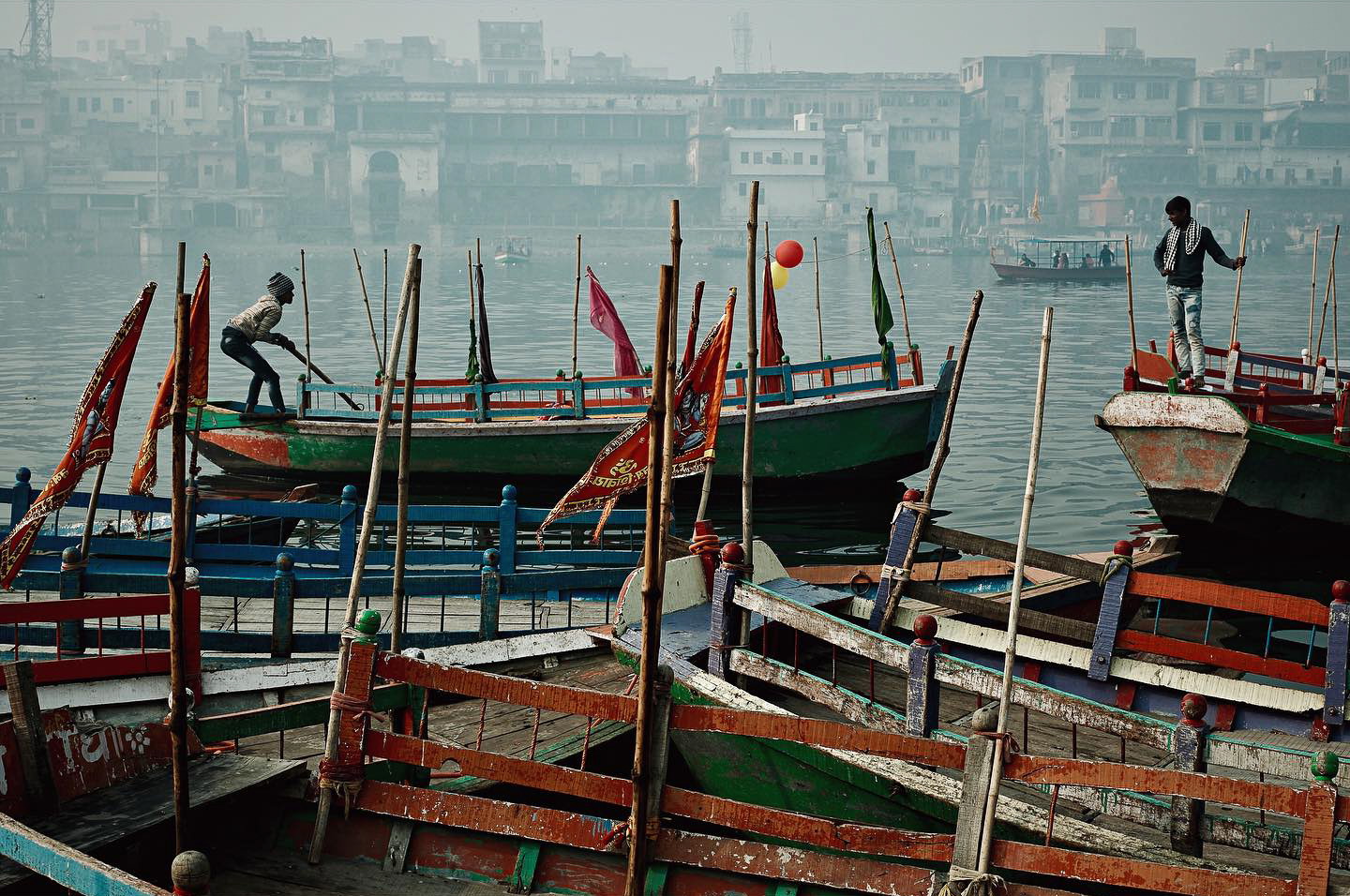 Travel photography by Gil Kreslavsky. Two men on wooden boats in a harbor