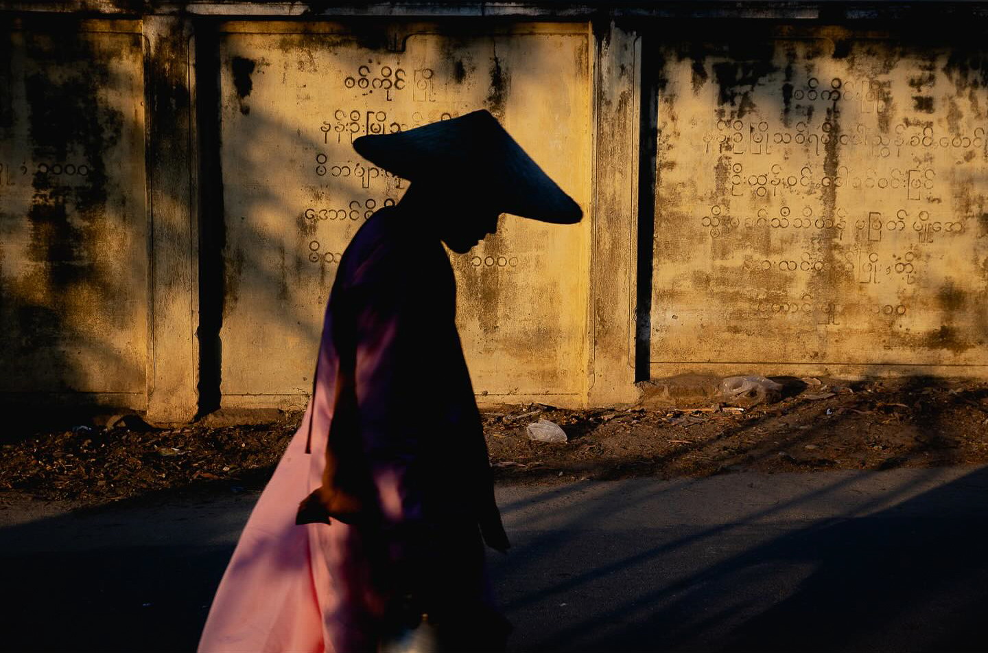 Travel photography by Gil Kreslavsky. Silhouette of a man in a traditional hat in Vietnam