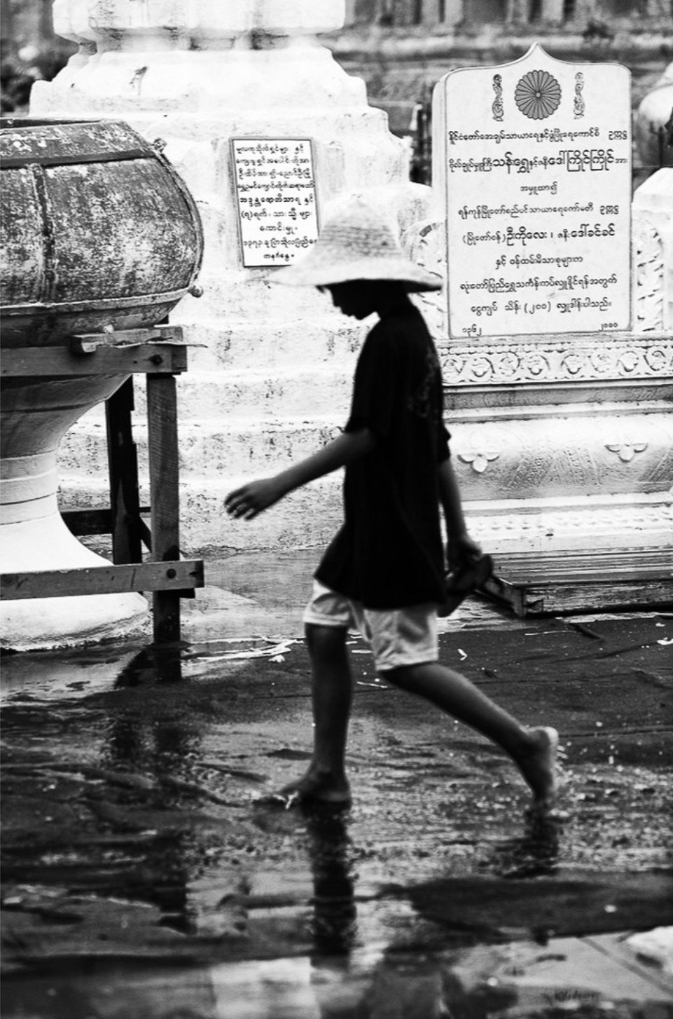 Black and white photography by Gil Kreslavsky. A boy walking on the street