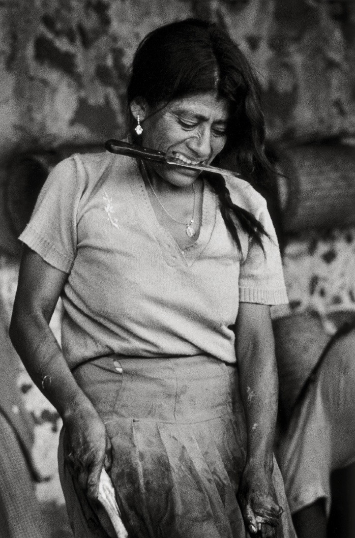 Black & white photography by Graciela Iturbide. Portrait of a woman with a knife in her mouth
