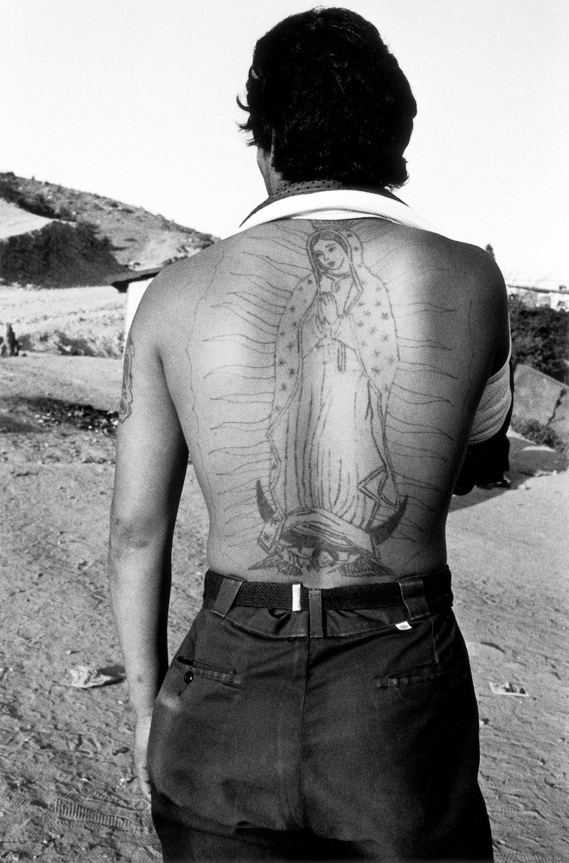 Black & white photography by Graciela Iturbide. Portrait of a man from the back with a large tattoo of the virgin on his back