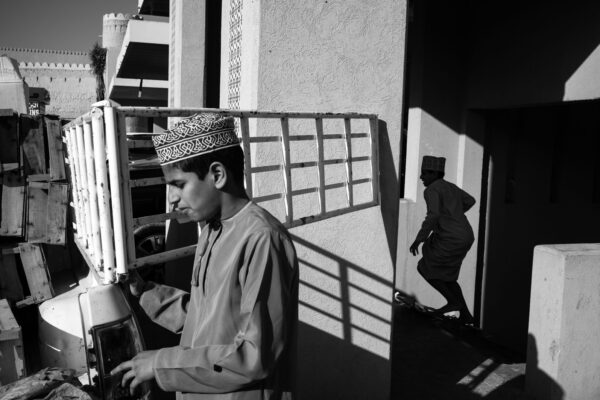 black and white street photo of boy at market in Nizwa, Oman by Mehdi Zouari
