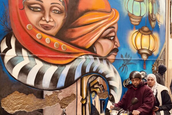 color street photo of man and woman on scooter in Marrakech by Paddy Butler
