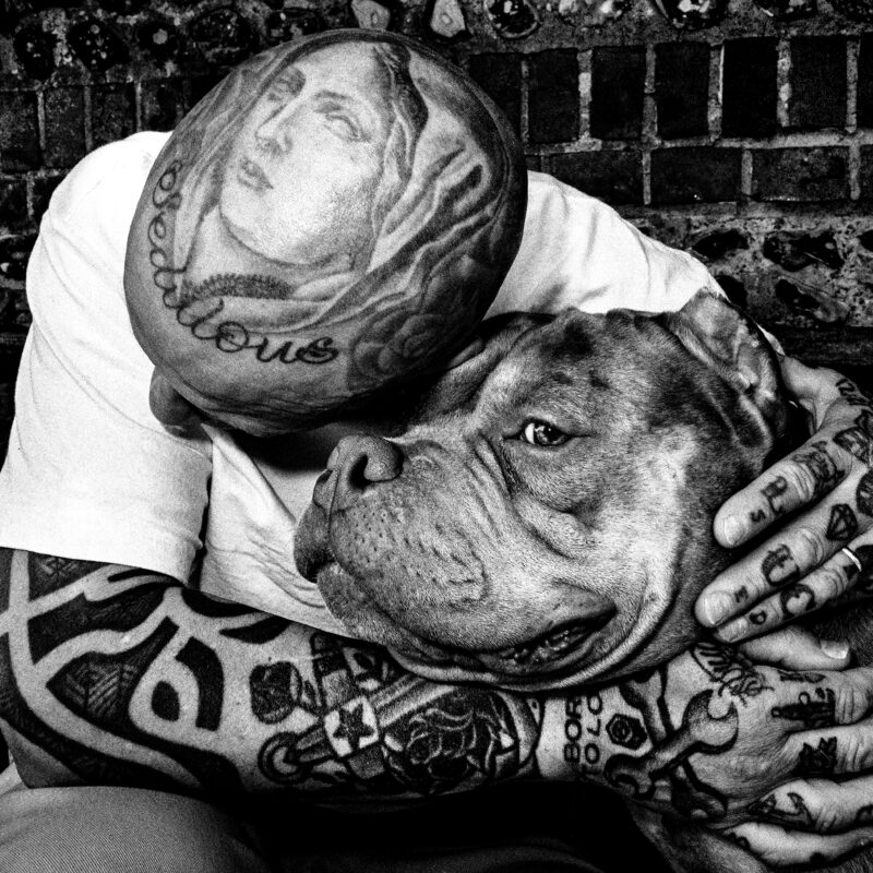 black and white street photography portrait of tattooed man and dog in Brighton, England, by Paul Spencer