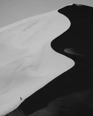 Black and white landscape photo of sand dunes in Morocco by Guillaume St-Amand