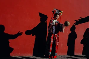 Color street photo of woman in traditional clothes in Beijing, China by Hamzah Lim