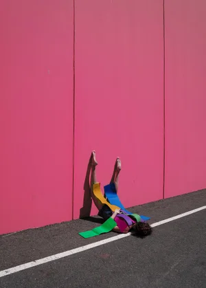 Conceptual fine art color portrait of woman against pink wall by Ana Garrido Santos