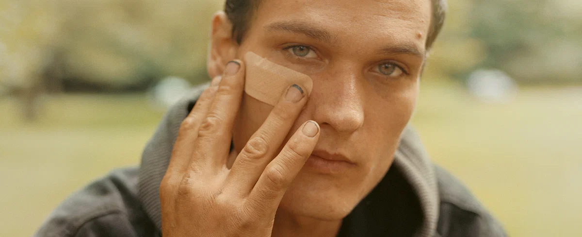 Documentary photography by Gregory Halpern. Portrait of a young man holding a plaster on his face