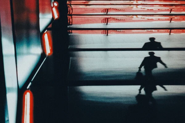 color street abstract photo of man walking under neon light in Montreal, Canada by Mathieu Dalle