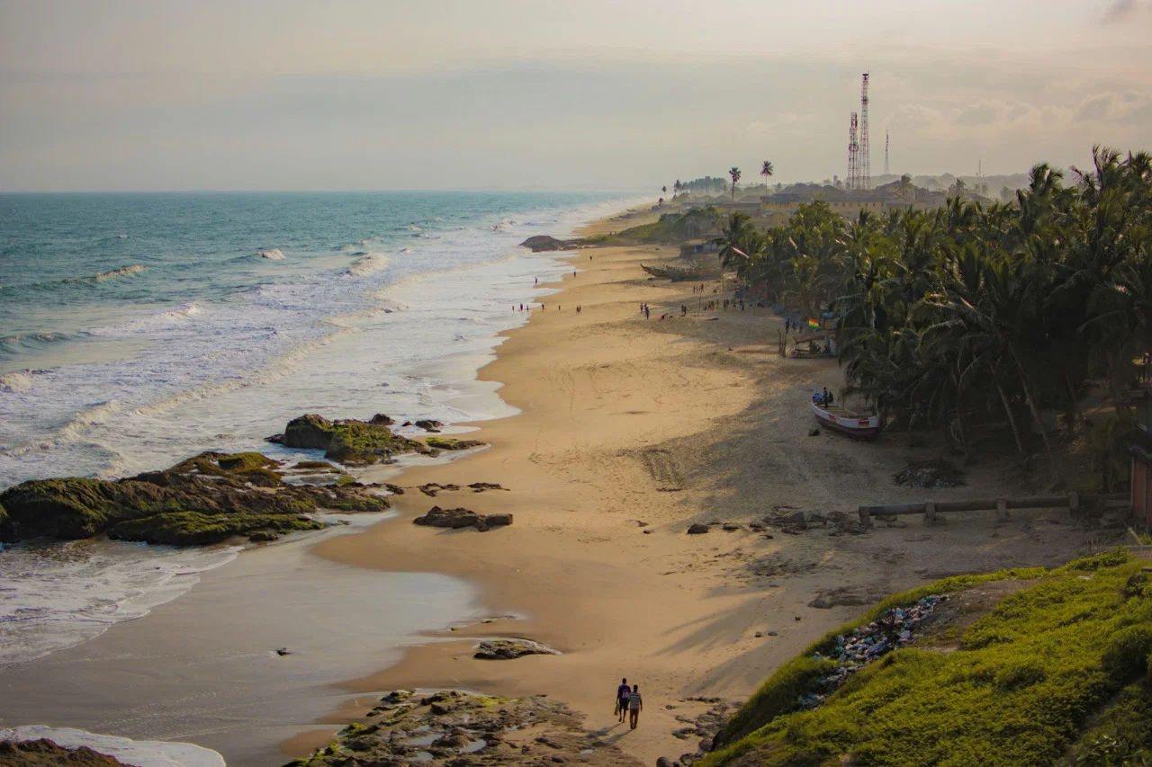 Aerial photo of a beach lined with trees in Ghana by Jared Poledna