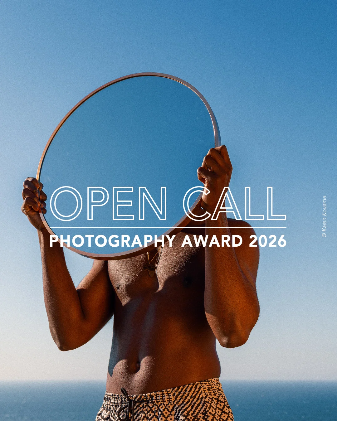 Color fine art portrait photo of man holding mirror by Karen Kouame. Open Call Award