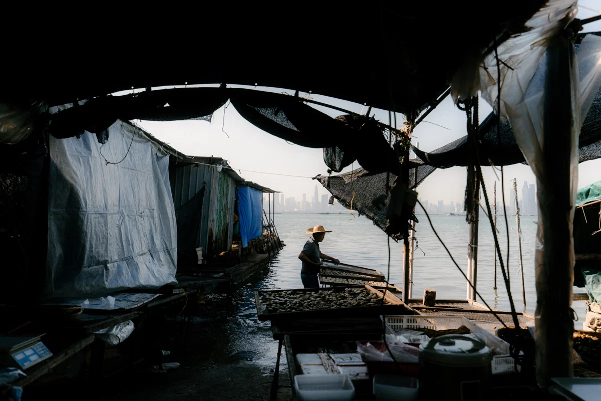 Color travel photo of fisherman and wooden beams of a coastal shelter near Hong Kong by Ho Ching Chiu
