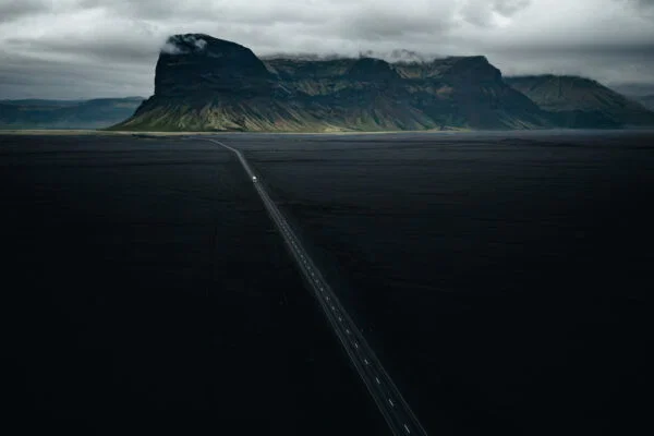 Color landscape photo of road and black sand in Iceland by Maria Lungu