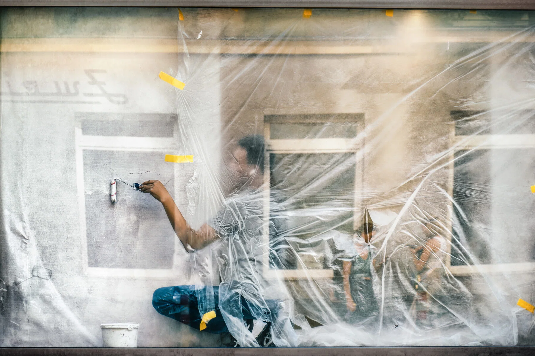Color street photography of man painting wall in Vienna, Austria by Asako Naruto