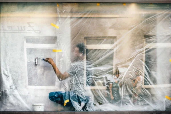 Color street photography of man painting wall in Vienna, Austria by Asako Naruto