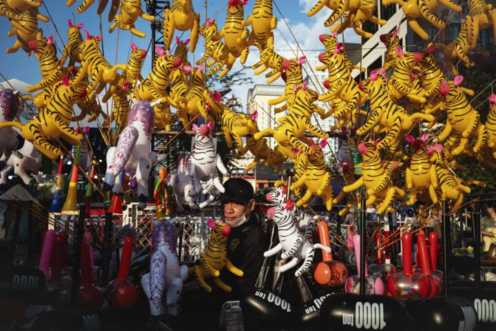 Color street photography of man with toy in Vietnam by Nicola Balestrazzi